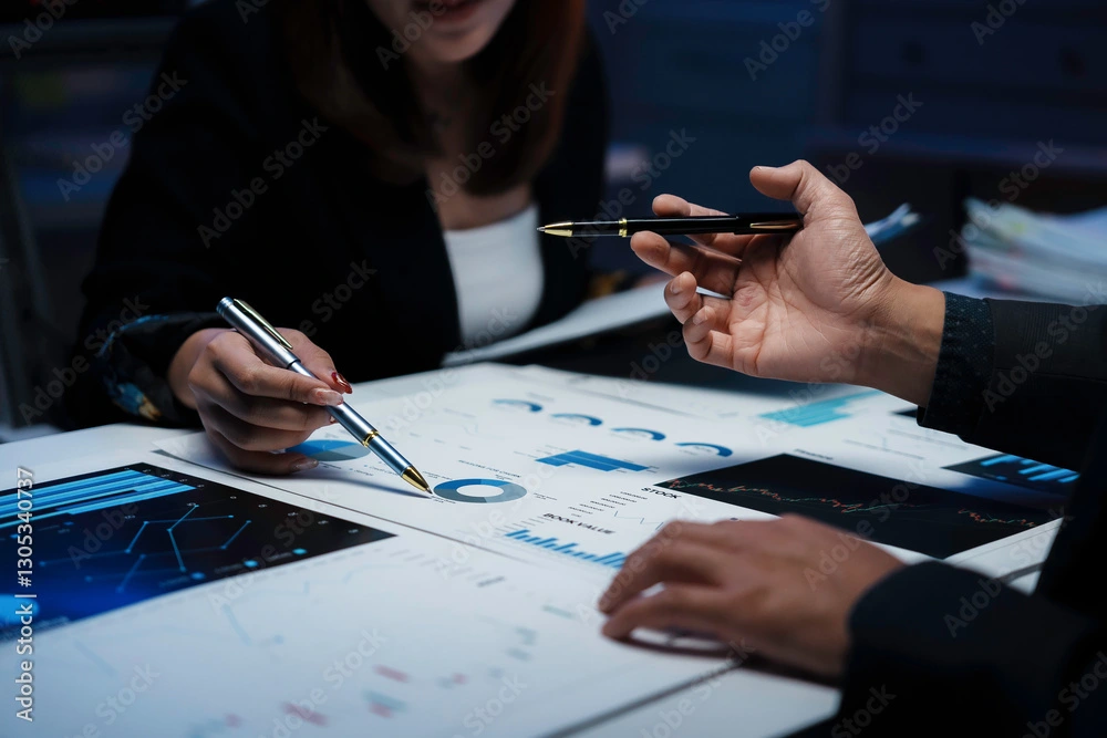 Business professionals reviewing financial charts at desk