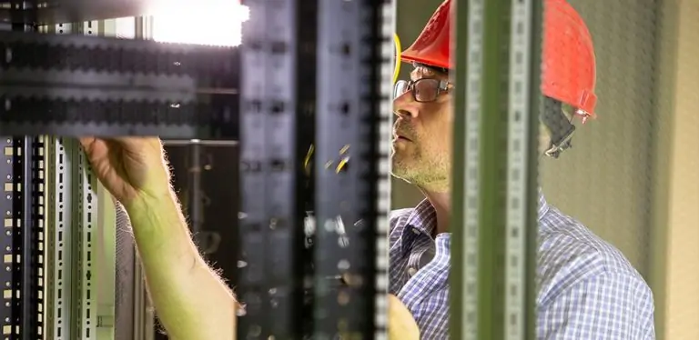 Technician in hard hat working on server rack