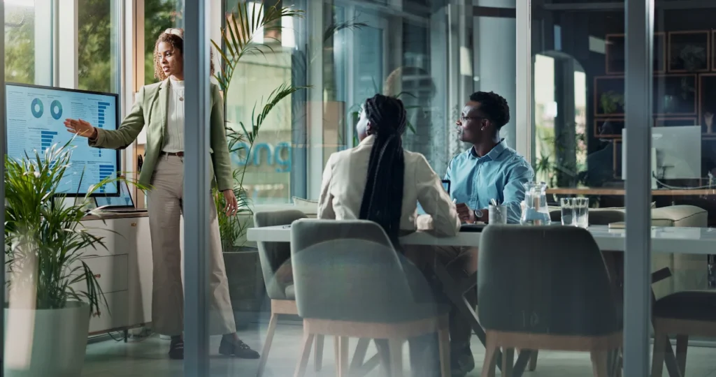 Businesswoman presenting charts during modern office meeting