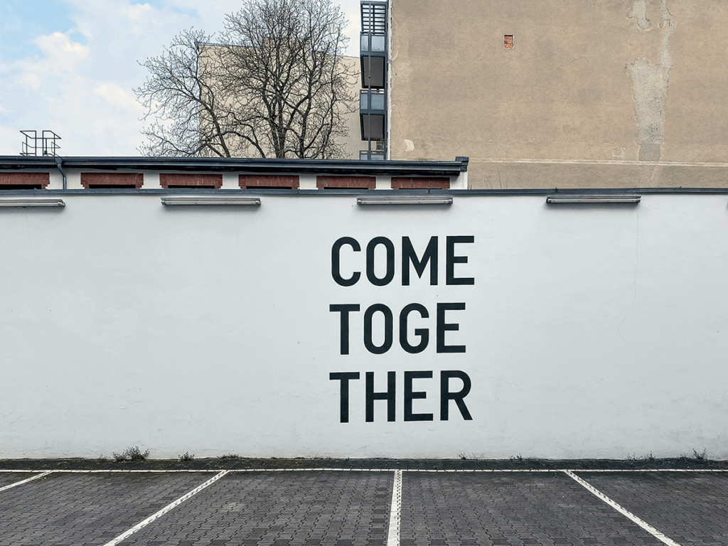 A photograph of a white wall with a stencil that says 