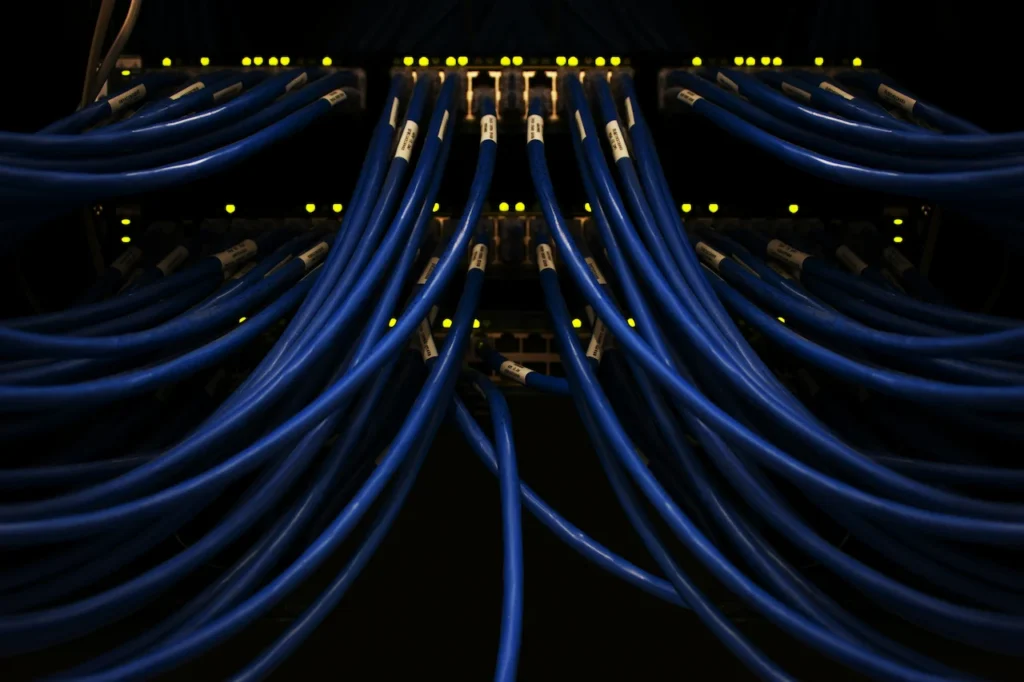 Blue Ethernet cables connected to network server rack