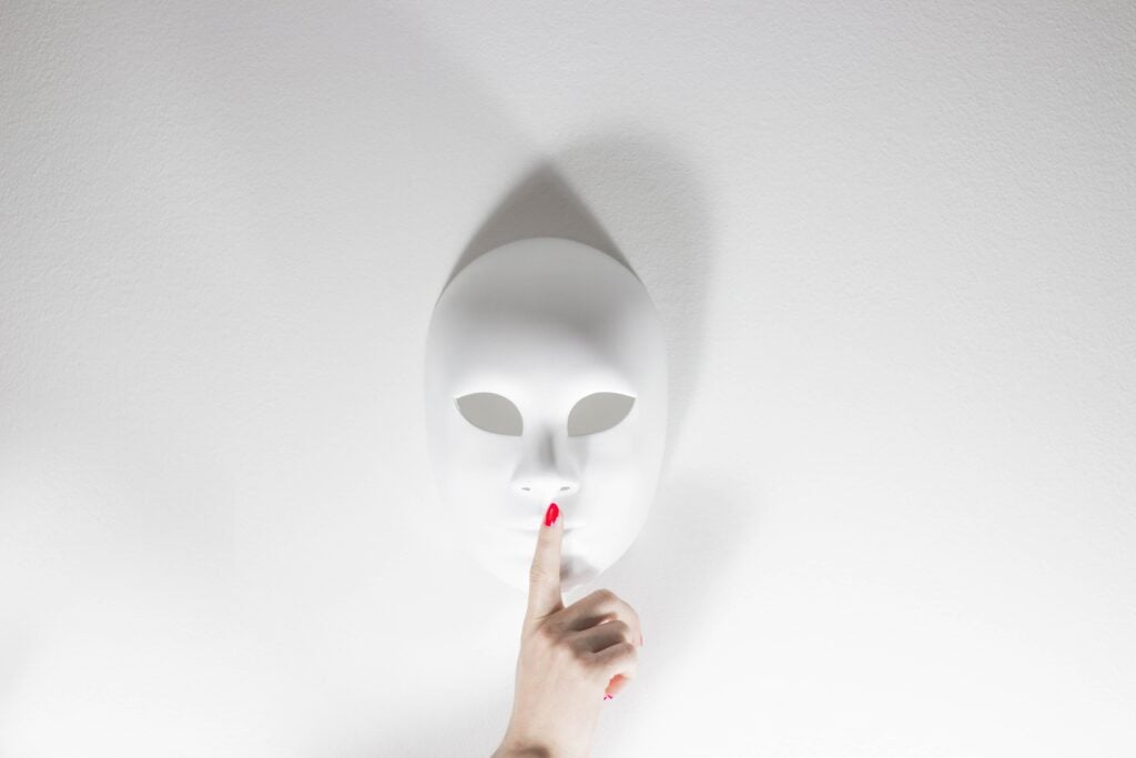Woman with red nails making a quiet gesture