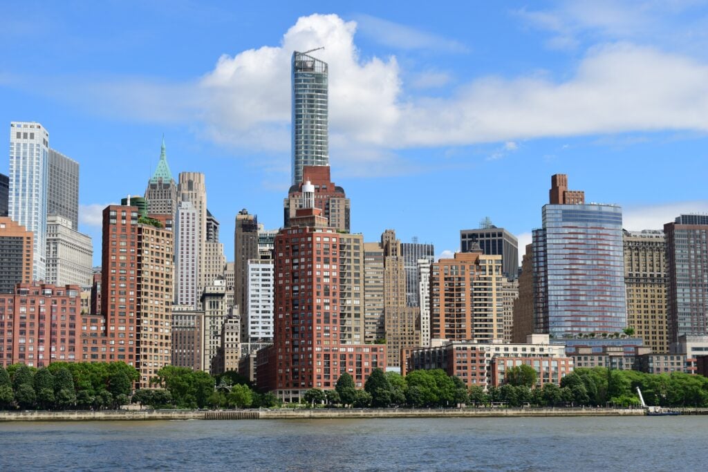 Manhattan skyline along Hudson River under blue sky