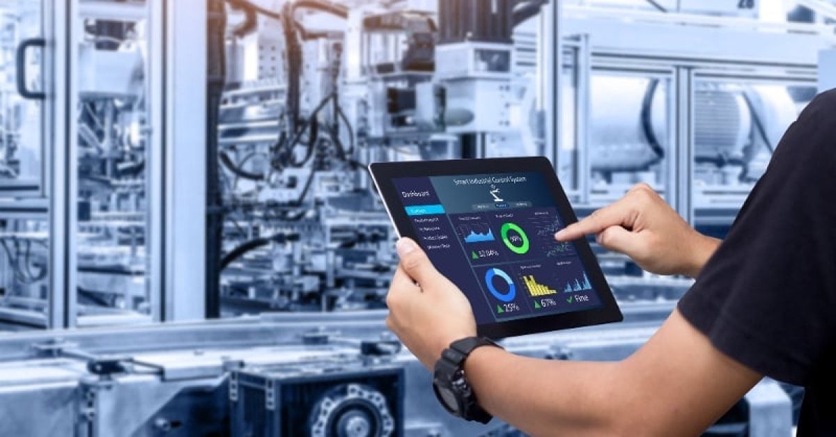 A man with an ipad controls large industrial equipment