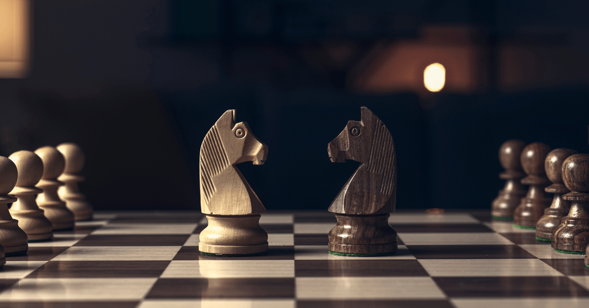 Chess pieces arranged on the chessboard and knights facing each other